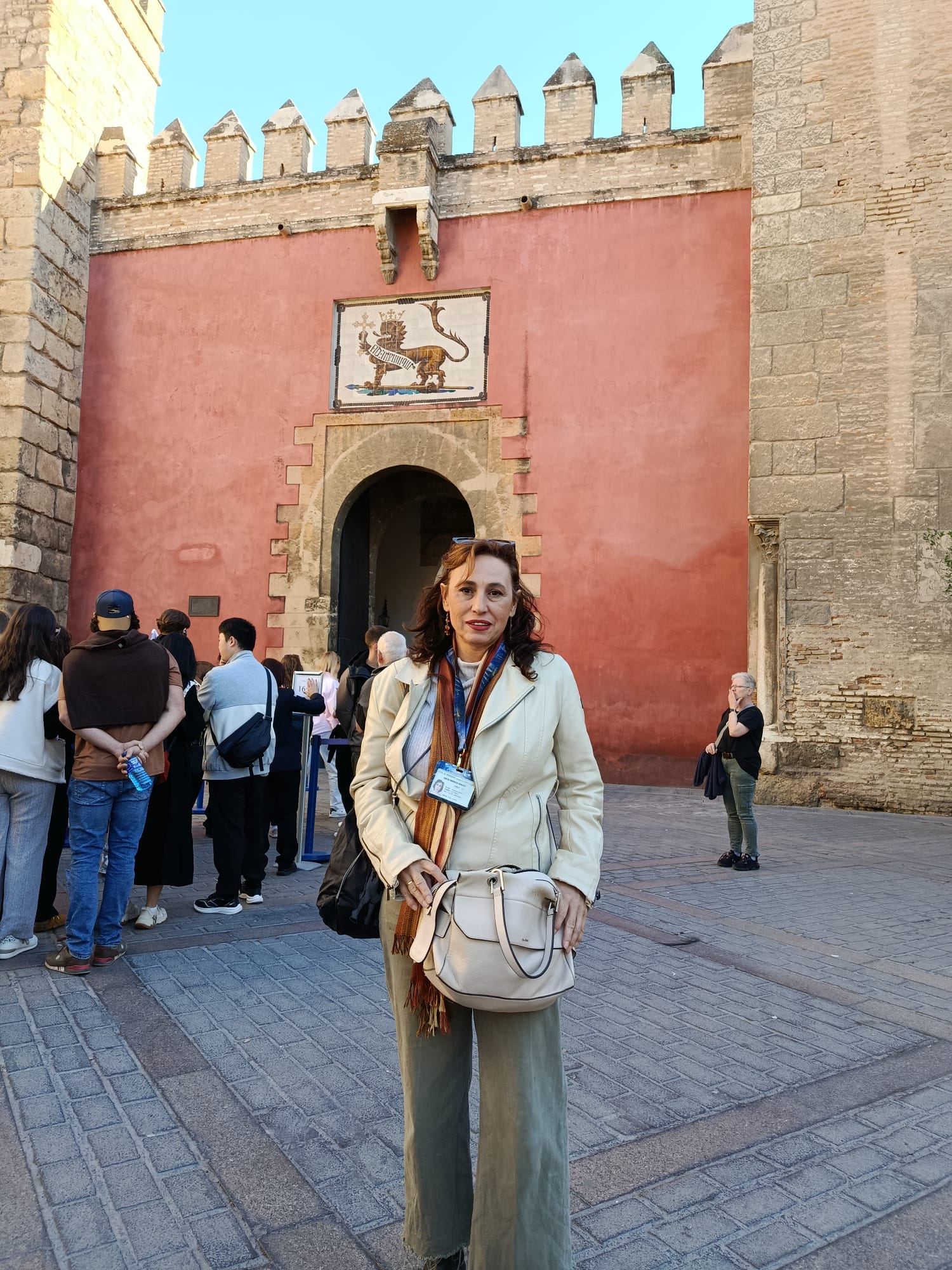 Carmen Ruiz delante de la Puerta de los Leones del Real Alcázar de Sevilla durante una visita cultural con Conoce Sevilla