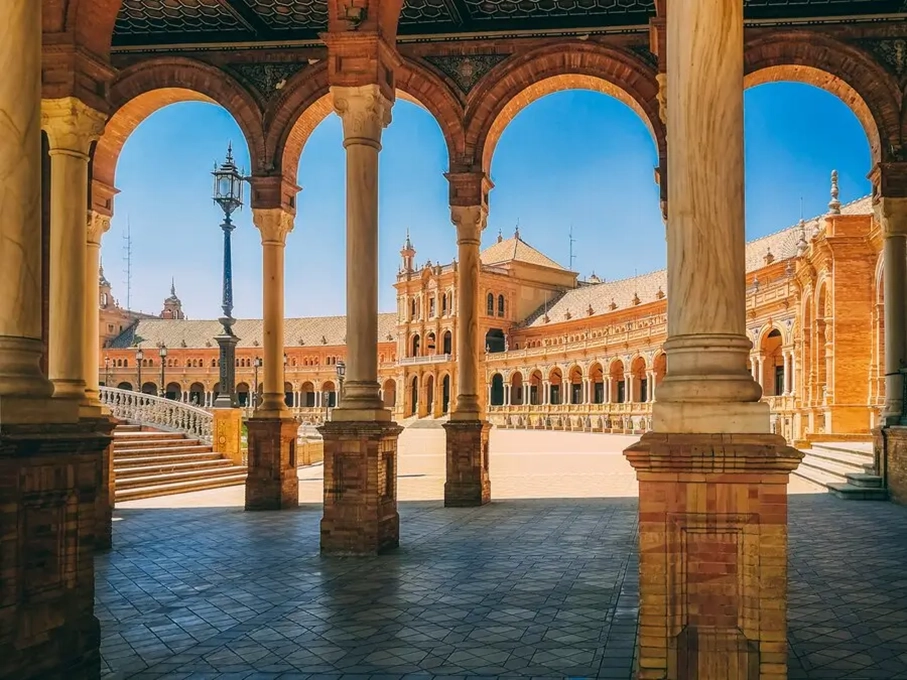 Plaza de España en Sevilla vista a través de los arcos del edificio central durante una visita cultural con Conoce Sevilla
