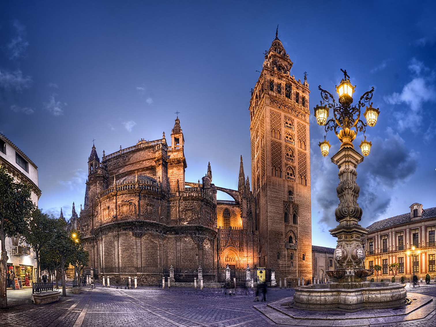 Catedral de Sevilla vista desde la Plaza Virgen de los Reyes con la fuente de la farola como elemento central durante una visita cultural con Conoce Sevilla
